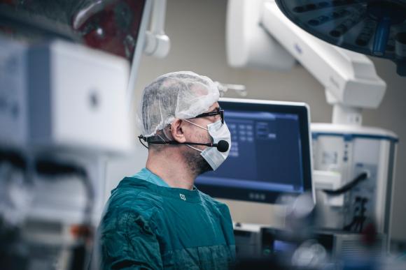 A surgeon wearing a face mask in the operating room.